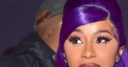 Cardi B showcases vibrant purple hair and bold makeup, exuding confidence at a glamorous event.