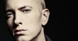 Eminem with short blonde hair, wearing a grey shirt and jacket, showcases his intense expression in a moody setting.