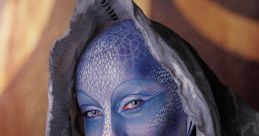 Female model with artistic blue face paint and elegant gray scarf, showcasing unique fantasy-inspired makeup design.