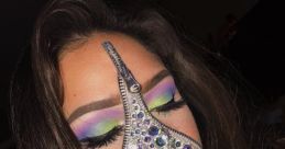 Fashion-forward individual wearing a jeweled mask with zipper details and vibrant eye makeup, showcasing creative artistry.