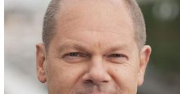 Olaf Scholz, German Chancellor, dressed in formal suit and patterned tie, poses confidently outdoors with a neutral background.