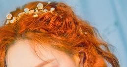 Taeyeon of Girls' Generation shows off her stunning orange hair and green eyes, holding a vibrant tulip in a dreamy setting.