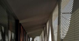 Modern architectural details of Bali Library showcasing perforated panels casting intricate shadows on the wooden floor.