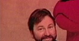 John Ritter smiles next to Clifford the Big Red Dog, showcasing their iconic bond from the beloved children's series.