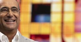 Carlo Conti smiles confidently in front of a colorful game show backdrop, showcasing his charismatic television presence.