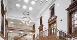 Elegant interior of the Bake Library featuring grand staircases, ornate woodwork, and striking black-and-white checkered flooring.