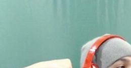 Charlie Guzman flexes his muscles while wearing red headphones, showcasing his enthusiasm and gaming personality.