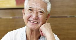 Smiling senior Asian man in a white polo reading documents at a cafe, exuding warmth and wisdom.