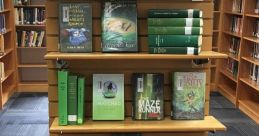 Book display featuring a selection of green-covered titles for high school teams in the library, promoting reading and engagement.