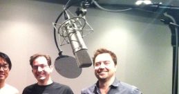 Darin De Paul in a recording studio, known for voicing Samuel Hayden in Doom video games. Behind him, studio equipment is visible.