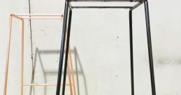 Minimalist black metal frame stand beside a rose gold stand, perfect for modern decor and functional design.