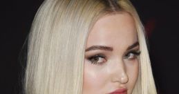 Dove Cameron showcases a stunning look with sleek blonde hair and striking makeup at a red carpet event.