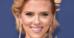 Scarlett Johansson smiles with glamorous makeup, wearing a stunning sequined dress at a red carpet event.