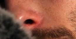 Close-up of a male ASMR artist softly speaking into a microphone, creating soothing sounds for relaxation and tingling sensations.