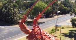 Giant lobster sculpture of Larry The Lobster by the roadside, showcasing intricate detailing and vibrant colors in a scenic setting.