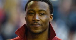 Brandon Marshall wearing a stylish red coat, showcasing his confident demeanor at a public event.