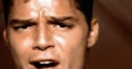 Ricky Martin singing passionately in a vibrant blue shirt, showcasing his iconic charisma and musical talent.