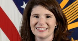 Heidi Smith poses confidently in professional attire against a backdrop of the American flag, showcasing her leadership role.
