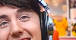 Dawko smiling in a yellow hoodie with headphones, featuring gaming-themed background elements.