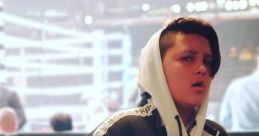 FGTEEV Mike posing in a stylish hoodie at a boxing event, showcasing a confident expression amidst a lively atmosphere.
