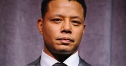 Terrance in a sharp gray suit, exuding confidence on stage with a serious expression, ideal for a professional setting.