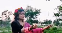 Woman in a pink saree dancing gracefully outdoors, showcasing traditional culture and vibrant attire against a lush backdrop.