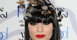 Jessie J showcases bold fashion with a unique headpiece and striking red lips at a high-profile event.