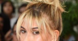 Hailey Helterbran showcasing a glamorous look with a chic hairstyle and sparkling gold outfit at a public event.