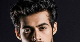 Stylish young man with tousled hair, wearing a white shirt, exuding confidence against a dark background. Keshav's charisma shines.
