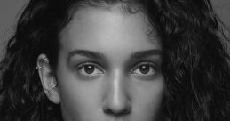 Stunning black and white portrait of a model with expressive eyes and voluminous curls, showcasing natural beauty and elegance.