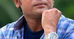 Anisur Rahman with a thoughtful expression, wearing a checkered shirt and a stylish watch, outdoors.