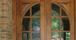 Elegant wooden double doors with arched tops and glass panes, framed by a classic brick entrance. Enhance your home's curb appeal.