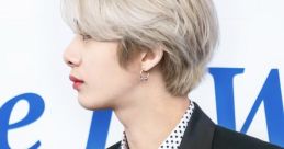 Stylish individual in a black tuxedo with a polka dot shirt, showcasing a modern and sophisticated look.