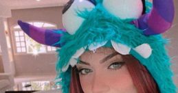 Miih Ares Azevedo poses with vibrant pink hair and a playful monster hat, showcasing her fun personality and style.