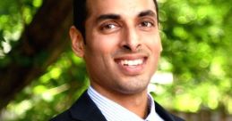 Professional portrait of Suhas M in a suit, smiling outdoors with greenery in the background, conveying confidence and approachability.