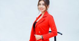 Vo Hanh showcasing a stylish red suit, exuding confidence and elegance while seated on a stool. Perfect for fashion inspiration.