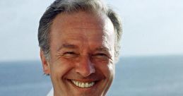 Smiling captain in a white uniform near the ocean, representing the spirit of "Traumschiff" voyages and adventures.