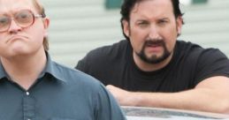 Bubbles and Lahey from Trailer Park Boys posing seriously by a car, showcasing their unique personalities and dynamic relationship.