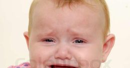 Crying baby with sad expression, wearing a colorful polka dot shirt. Evokes emotions and relatable moments of childhood sadness.