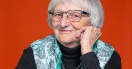 Smiling elderly woman with short gray hair, wearing glasses and a turquoise vest, against a vibrant orange background.