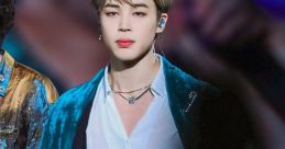 JiMin from BTS performing on stage, wearing a stunning turquoise outfit, captivating the audience with his presence.
