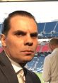 Christian Martinoli in a press box, focused, showcasing his passion for Mexican football commentary and sports journalism.