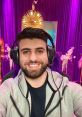 SypherPK smiling in gaming setup, ready to stream Fortnite, wearing headphones with a vibrant purple background.