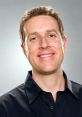 Geoff Keighley smiling against a gray background, known for hosting video game awards and industry events.