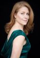 Elegant portrait of Jane Perry in a green satin dress, showcasing her graceful profile against a black background.