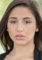 Young woman with long hair and natural makeup, showcasing a confident expression and captivating gaze, embodying beauty.