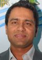 Aakash Chopra smiling in a formal attire, showcasing his engaging personality and connection to cricket commentary.