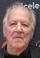 Werner Herzog at a film event, showcasing his iconic gaze and distinctive style, reflecting his unique cinematic vision.