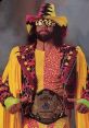 Randy Savage, known as Macho Man, poses in vibrant gear with a championship belt, showcasing his iconic wrestling style.