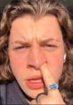 Lukedidthat making a funny face while playfully interacting with his nose, showcasing a light-hearted moment.
